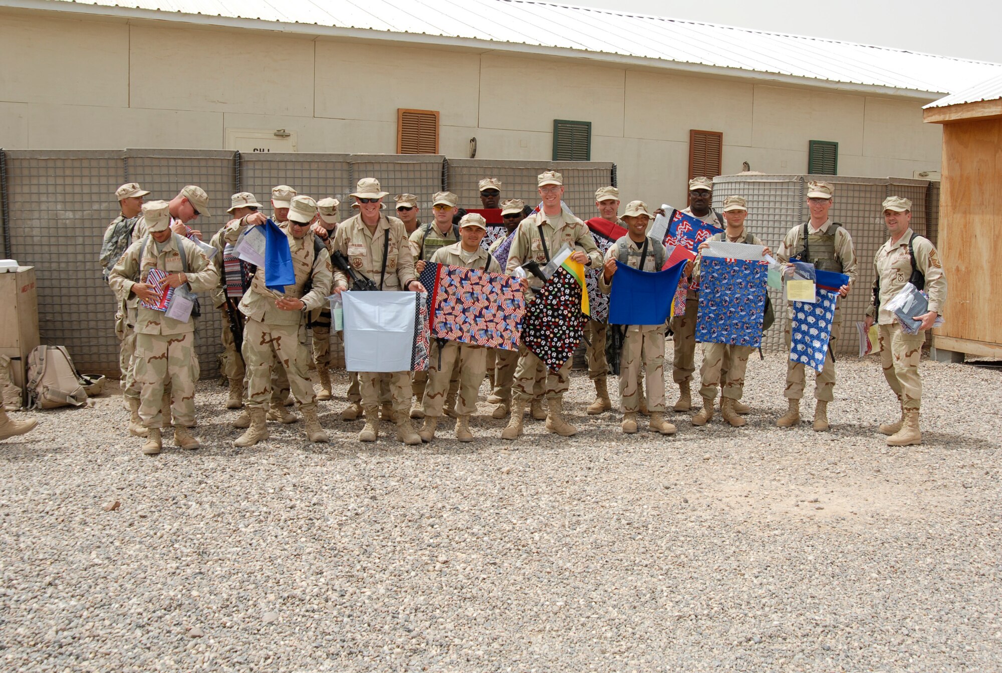 CAMP BUCCA, Iraq -- Members of the 886th Expeditionary Security Forces Squadron hold up pillow cases made and donated by the community of Concord, Calif. "Operation Pillowcase" ensured that every member of the 886th recieved a reminder of home.(AF photo/Elias Ibay)