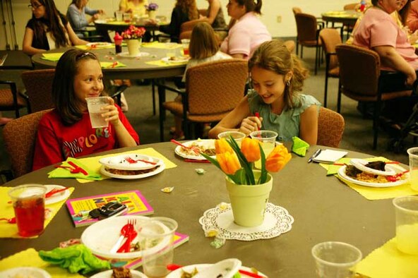 SHAW AIR FORCE BASE, S.C. -- Lauren Bishop (left), daughter of Gloria and Tech. Sgt. Keith Bishop, 20th Civil Engineer Squadron, and Cassidy Bauer (right), daughter of Kelley and Staff Sgt. Brian Bauer, who is currently serving a remote assignment at Kunsan Air Base, Korea, attend the monthly dinner for spouses and children of military members who are deployed or on a remote assignment. The dinner was hosted by the 20th Fighter Wing Chapel on April 23. Games and craft activities for children are also held at the event. The next dinner is 6:30 p.m. May 14 in the community center. (U.S. Air Force photo/Kimberly Champagne)