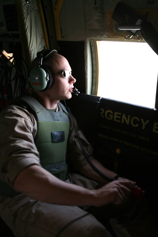 AL ASAD, Iraq - Cpl. Brian Morgan, a loadmaster with Marine Aerial Refueler Transport Squadron 252 Detachment Alpha, watches out the window of a C-130J "Hercules" as it takes off from the Al Asad flight line, April 25. Loadmasters act as a lookout in a combat zone, watching areas that the pilots can not.