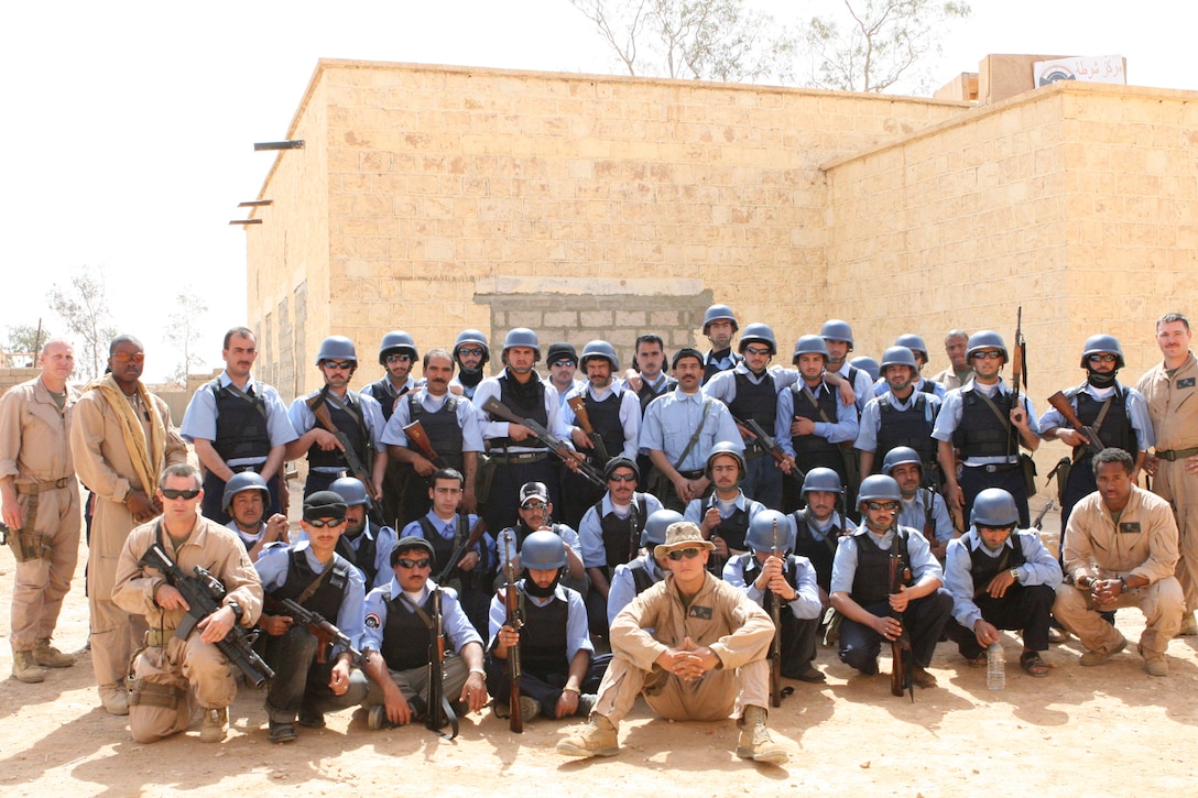 The ?Son?s of Rutbah,? as the new members of the city?s police force are referred to, gather for a photo with their mentor and counter parts, the Marines and sailors of Police Transition Team 21 during a break in their training.