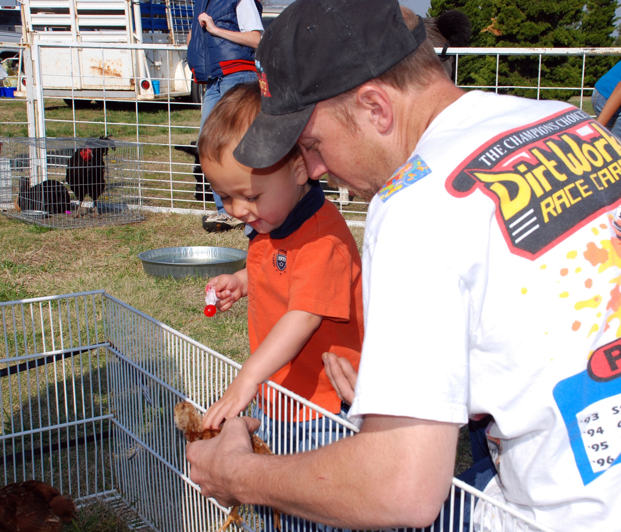 Isaac Vorderlandwehr and his father James Vorderlandwehr pet a baby duck at the petting zoo at the ninth annual Family Festival of Fun here April 21 at the Robert J. Dole Center. (Photo by Airman 1st Class Jessica Lockoski)