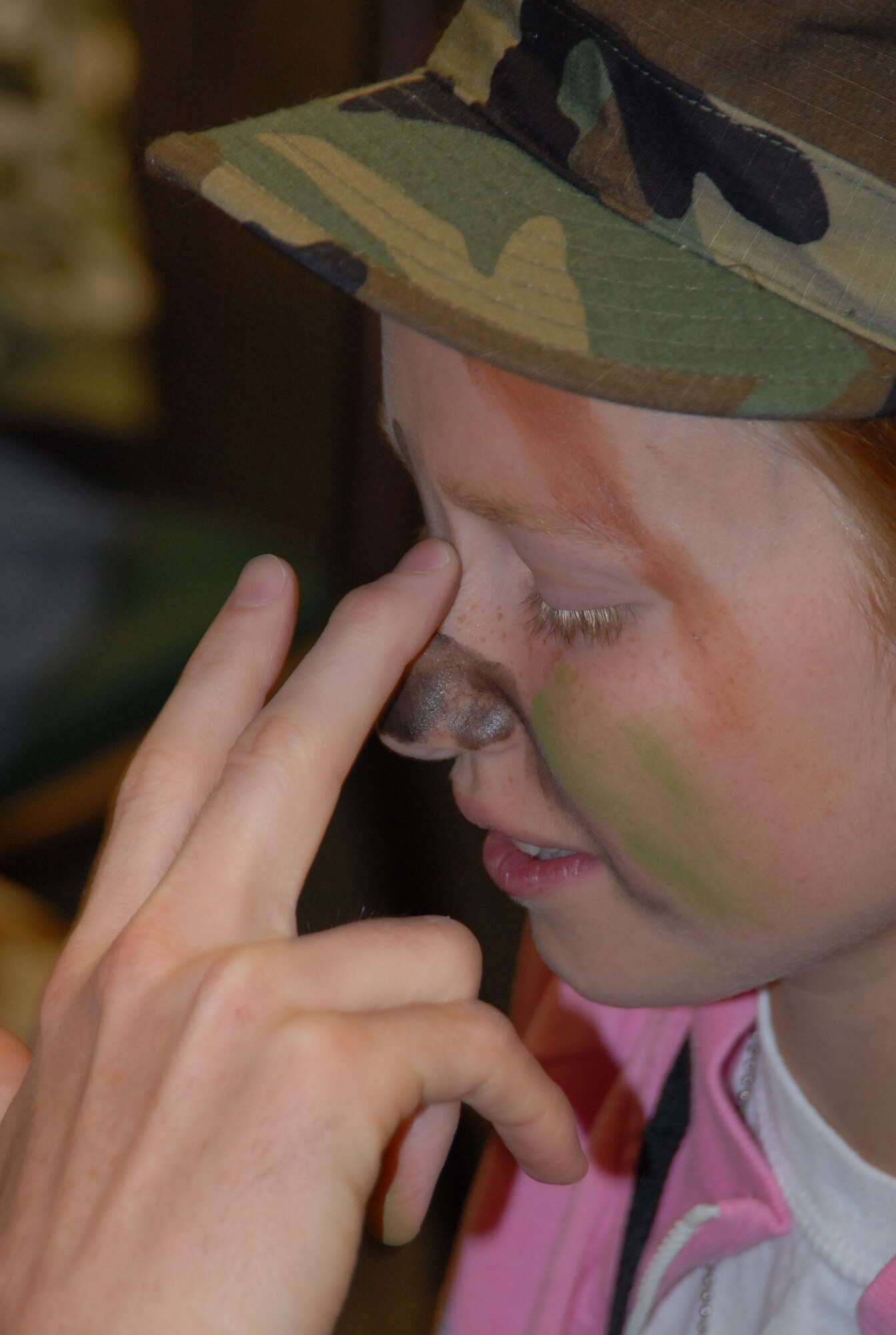 Caitlyn Lane, 11, has her face painted during Operation KUDOS at the Oasis Community Center on Saturday. (Photo by Airman Mikeal A. Young)