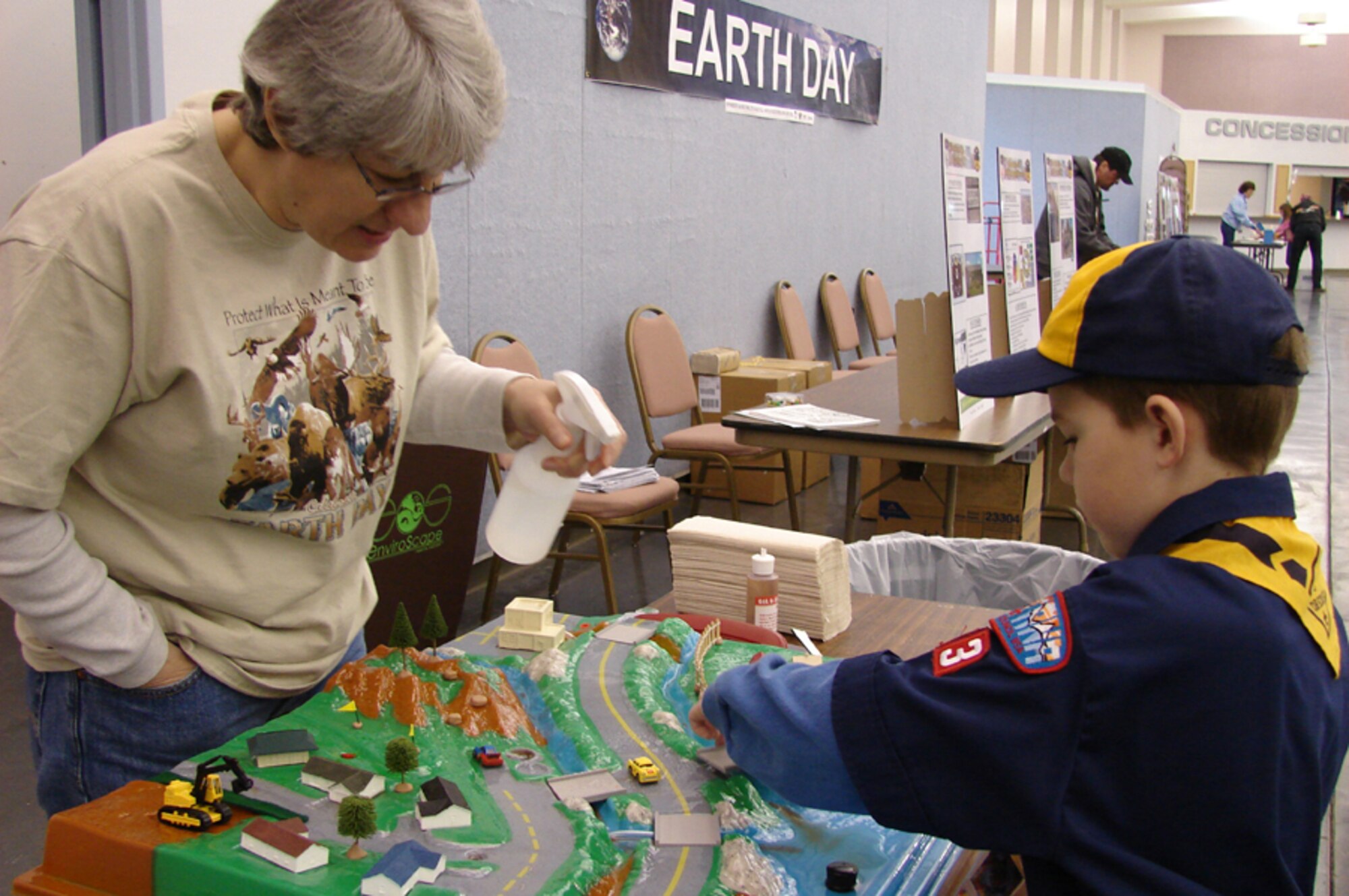 Lana Hedlend, an environmental engineer with the 341st Civil Engineer Squadron, and Little Warrior, Jakob, 8, a member of Cub Scout Pack 43 at Malmstrom, test the various ways storm water can be contaminated before ending up at its final destination. The demonstration was part of Earth Day festivities at the Great Falls Civic Center April 22.
