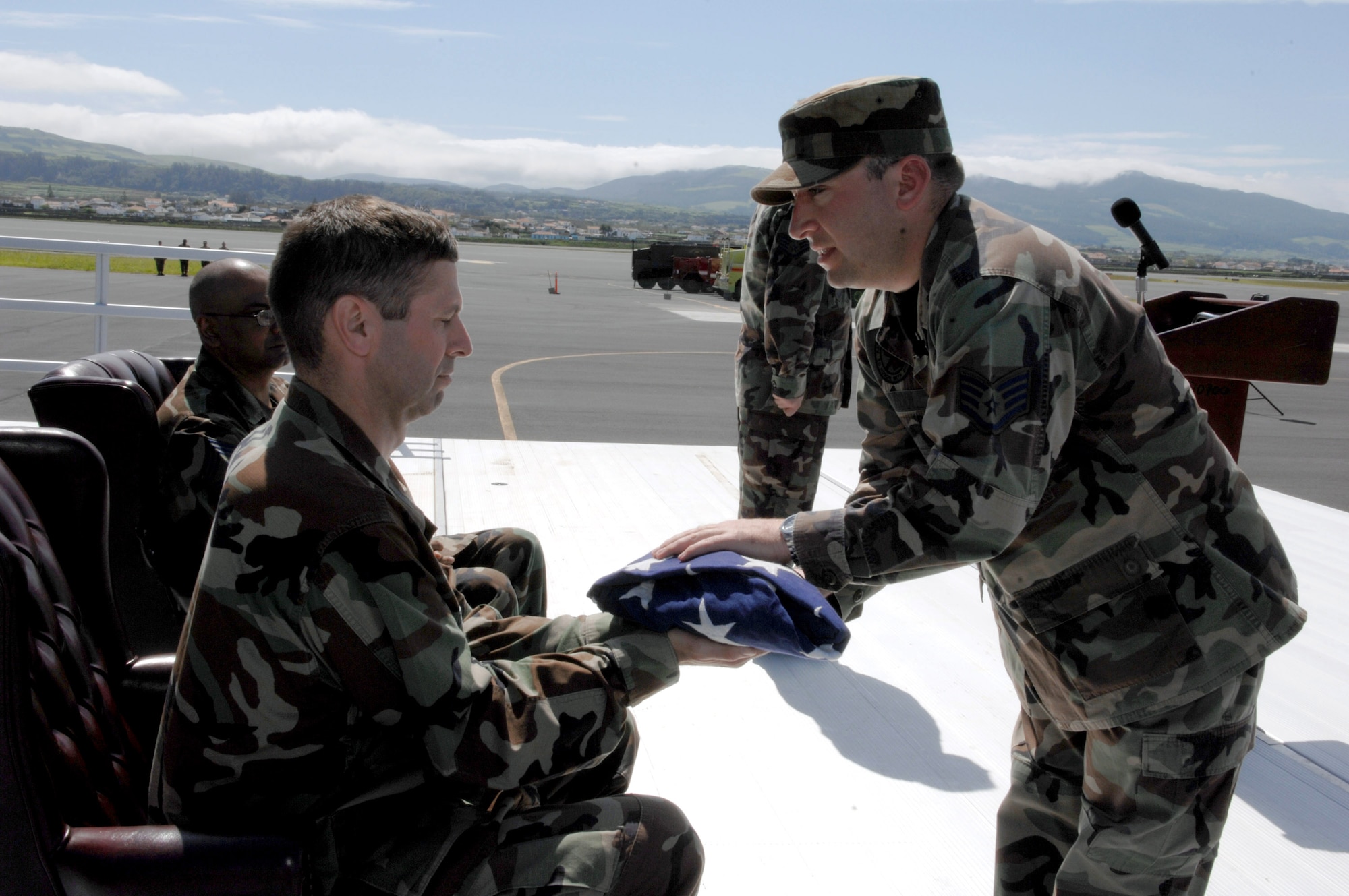 Staff Sgt. Chris Parodi presents Col. Jeffery Derrick with a flag symbolizing lives lost by fallen Airmen as a result of drunk driving. Colonel Derrick is vice commander of the 65th Air Base Wing at Lajes Field, Azores. Sergeant Parodi is NCO in charge of the Lajes honor guard. (U.S. Air Force photo/Guido Melo)
