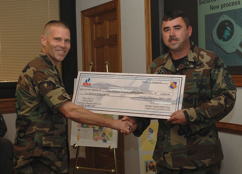 Colonel Steve Kwast, 4th Fighter Wing commander, presents Tech. Sgt. Anthony Evans, 4th Equipment Maintenance Squadron, a check for $10,000 April 19 for his proposal submitted to the Innovation Development through Employee Awareness program. (U.S. Air Force photo by Senior Airman Micky Bazaldua)