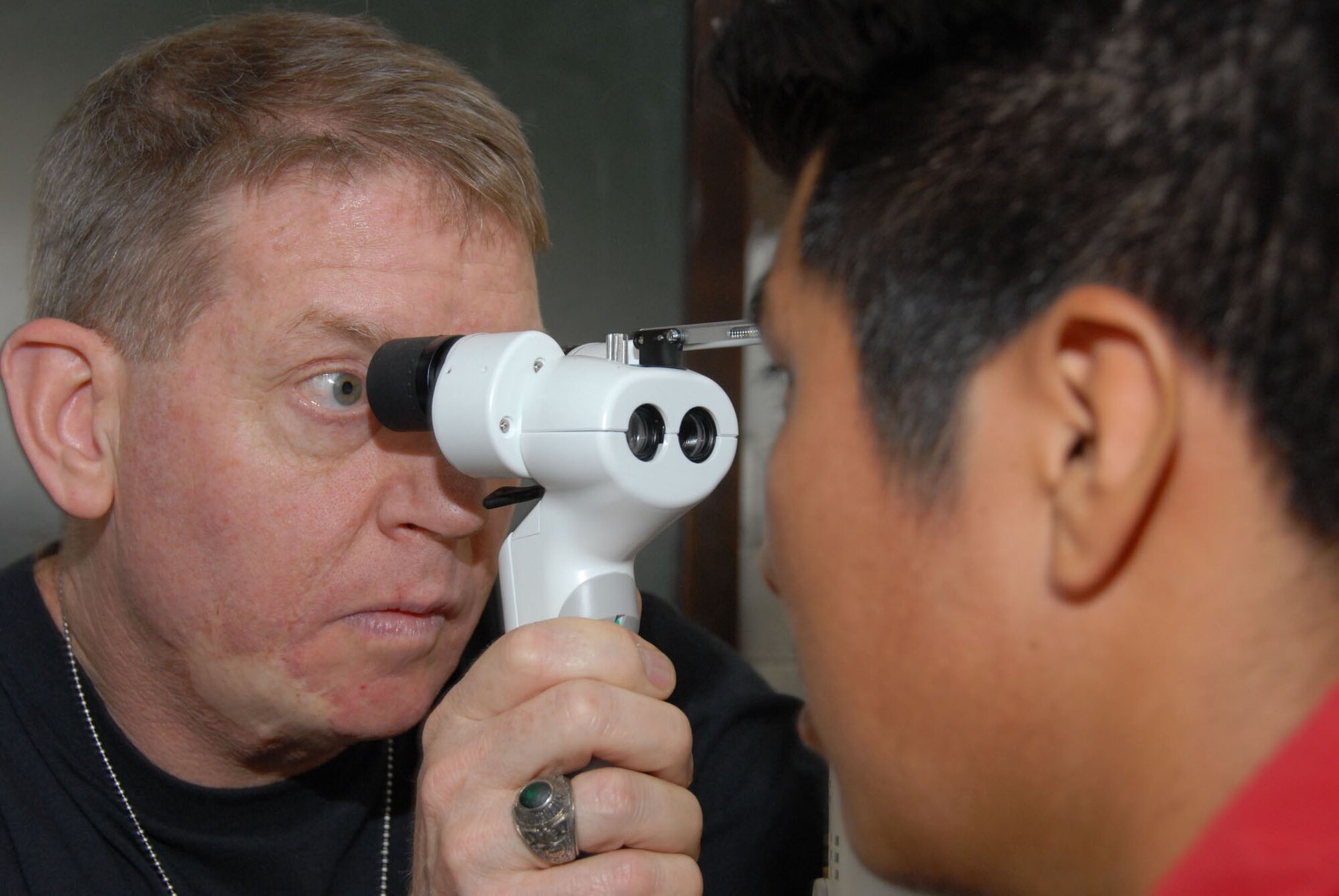 Lt. Col. (Dr.) Clifton Poling, an optometrist with the Air Force Reserve Command's 445th Aerospace Medicine Squadron, Wright Patterson Air Force Base, Ohio, examines the front of the eye of a Guatemalan with a hand held slit lamp during the New Horizons Medical Readiness Training Exercise conducted in the San Marcos region April 14-28, 2007. More than 750 pair of presription eyeglasses were given during the exercise. (Air Force photo/Master Sgt. Chance C. Babin)