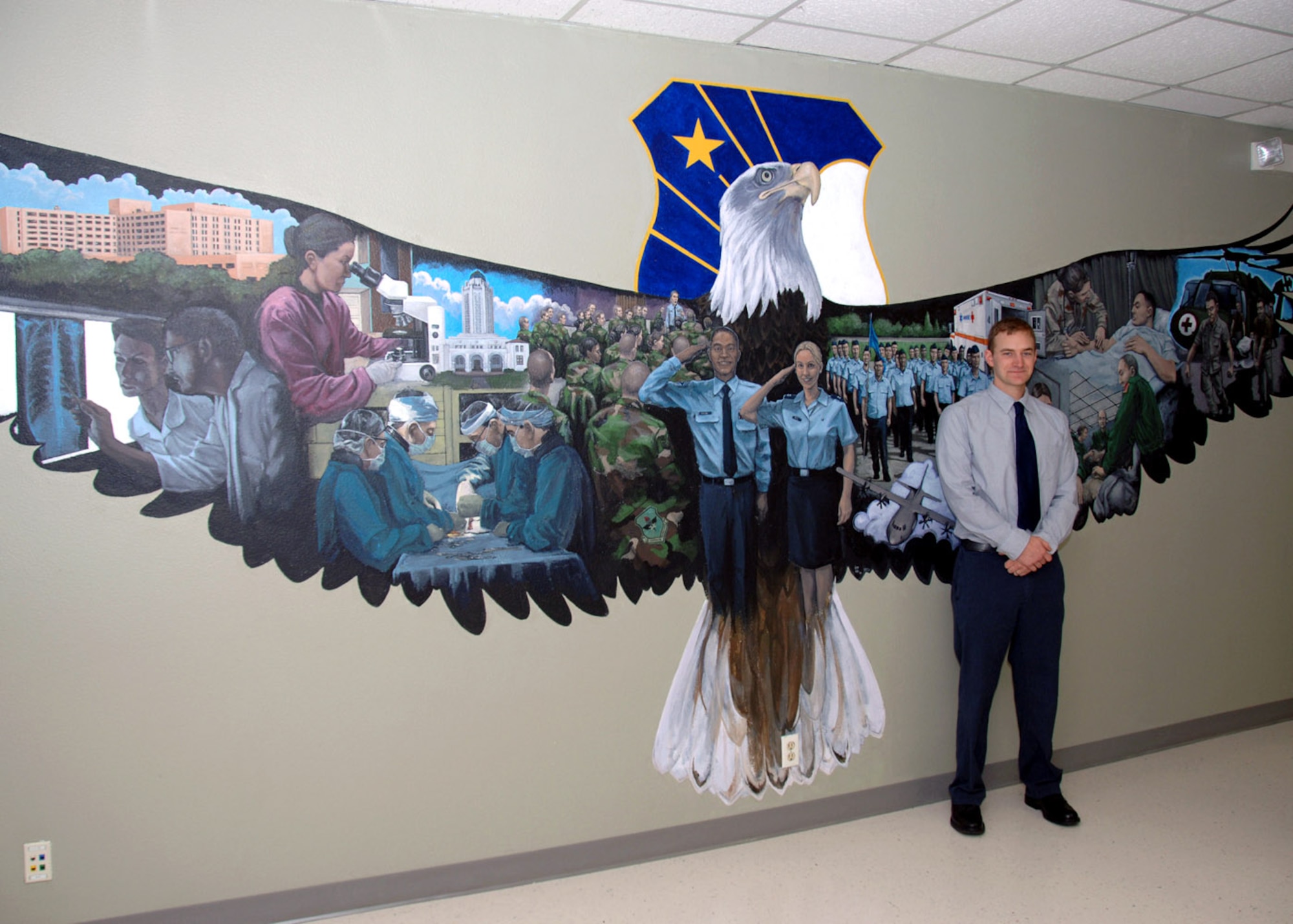 Artist Jacob Galey, husband of Capt. Lisa Mull a psychology resident with the 59th Medical Operations Squadron, stands beside his artwork April 24 at Camp Rissington, on Lackland Air Force Base, Texas. The mural, a first for Mr. Galey, took 180 hours in more than a three-month time period. (U.S. Air Force photo/Staff Sgt. Ruth Stanley)