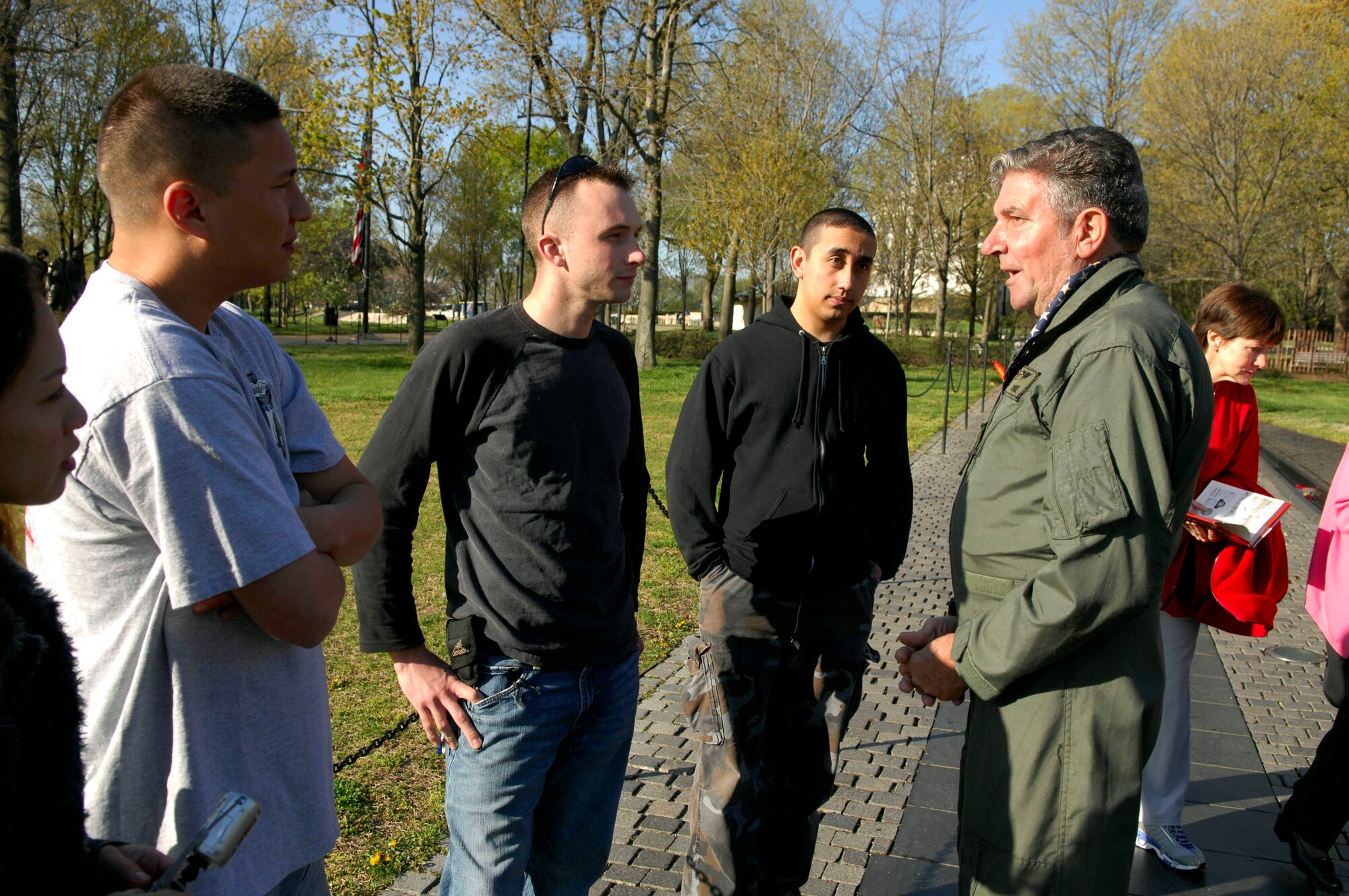 Lloyd McCabe (right) tells Airmen about his experiences in Hanoi at the Vietnam Memorial Wall in Washington, D.C., April 21. Members of the Air Force Sergeants Association, with volunteers from Charleston, Shaw, Pope, Seymour Johnson, Langley and Bolling Air Force Bases, were among those who helped clean the memorial. (U.S. Air Force photo/Tech. Sgt. Cohen A. Young) 