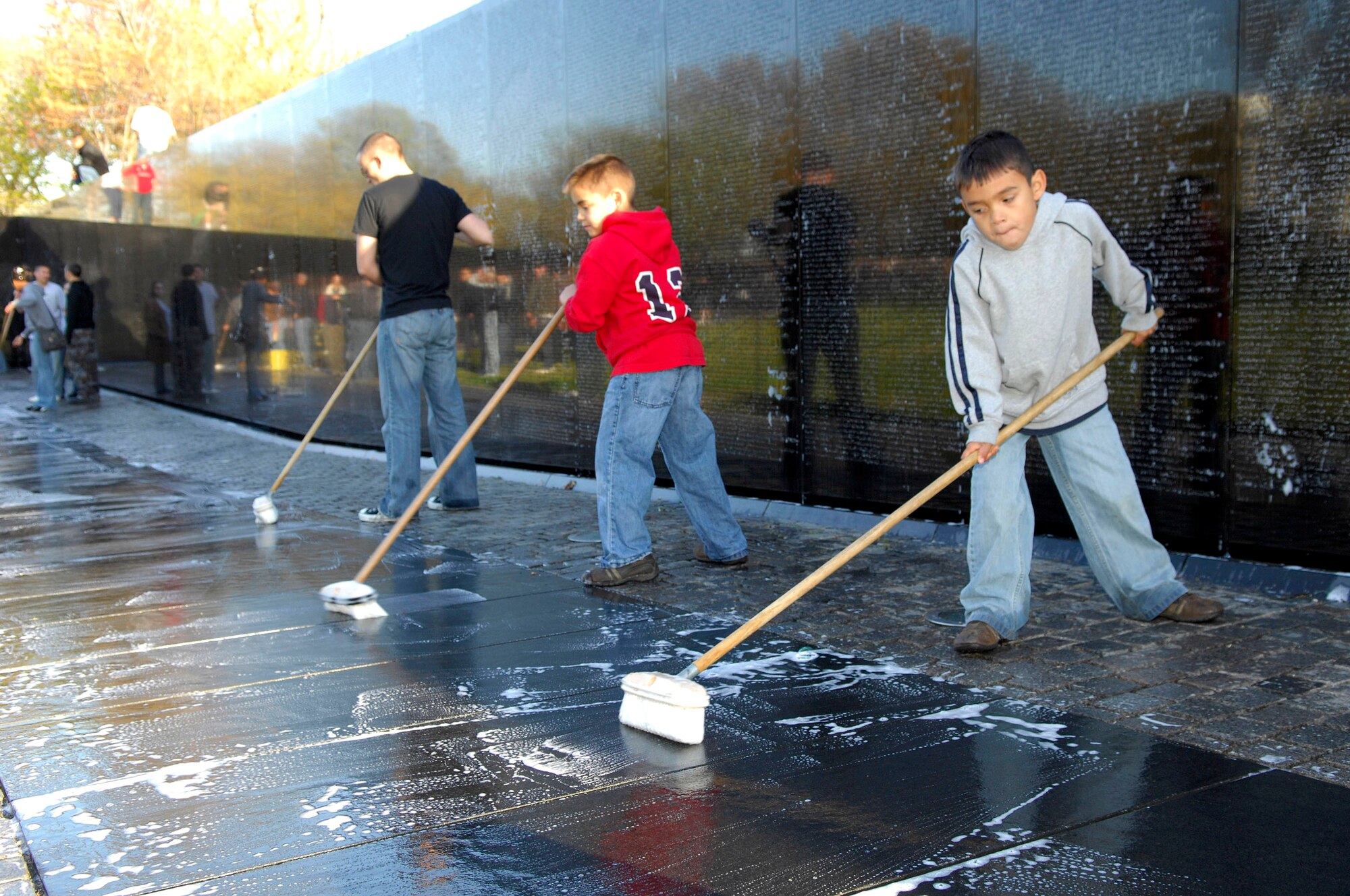 Nine-year-old Christian Williams (center) and 6-year-old Phoenix Williams scrub panels at the Vietnam Veterans Memorial in Washington, D.C., April 21.  Members of the Air Force Sergeants, with volunteers from Charleston, Shaw, Pope, Seymour Johnson, Langley and Bolling Air Force Bases, were among those who helped in the project. The boys are the sons of Staff Sgt. Leslie Williams, assigned to Seymour Johnson AFB, N.C. (U.S. Air Force photo/Tech. Sgt. Cohen A. Young) 