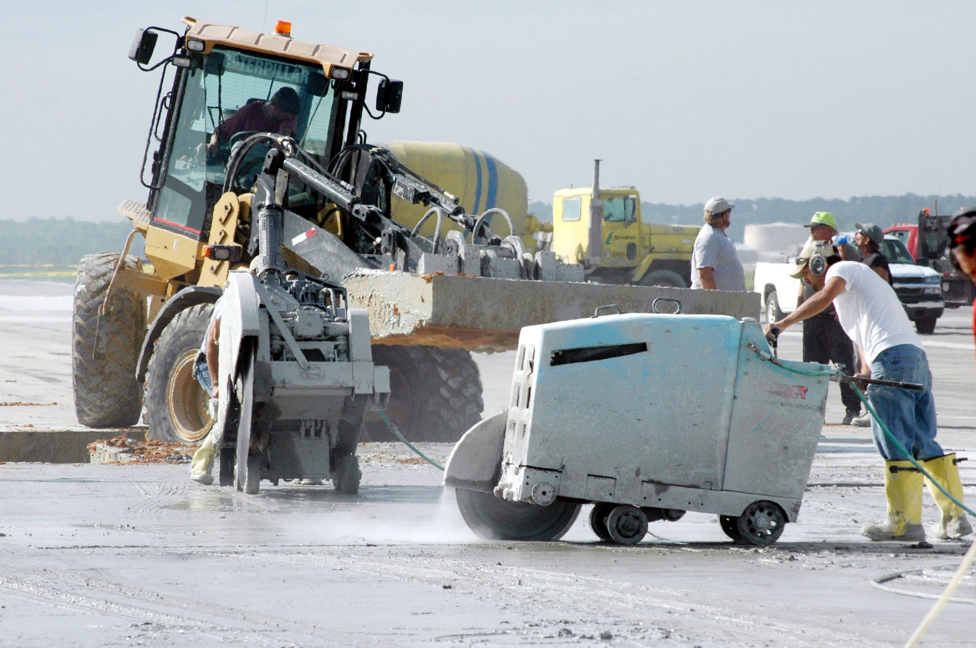 Crew members work to put in the last piece of concrete on the runway in June, 2004. Similar work is being done to the north side of the flightline, which will be closed May 4-18. Forty concrete slabs and 90,000 linear feet of joint seals will be replaced. The project will cost about $1.5 million. U.S. Air Force file photo by Sue Sapp