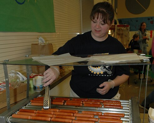 FAIRCHILD AIR FORCE BASE, Wash. – Amanda Robinson, Michael Anderson Elementary School Parent Teacher Organization president, cooks hot dogs during a carnival at Michael Anderson Elementary School April 21. More than 125 people volunteered to help with the carnival, which was held to raise money for the school’s PTO. (U.S. Air Force photo/Staff Sgt. Kristian Carter)
