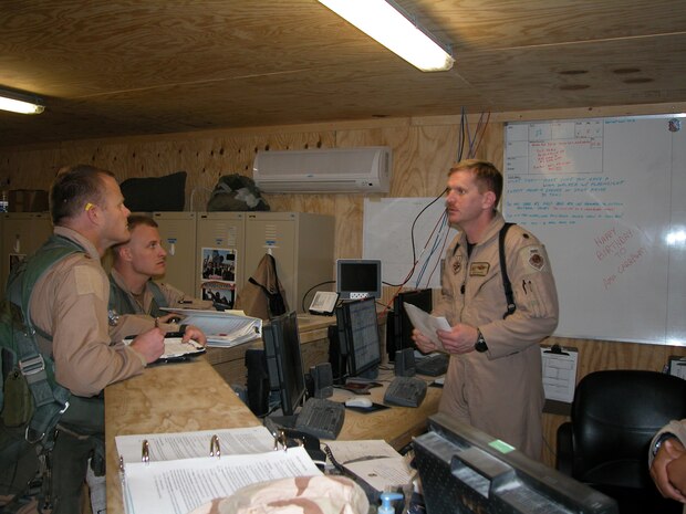 AL ASAD AIR BASE, Iraq — Lt. Col. Russ "Oscar" Myers, commander of the 74th Expeditionary Fighter Squadron, goes over a pre-flight mission briefing with Maj. Robert "Notch" MacGregor, 74th EFS assistant director of operations (front, left) and 1st Lt. Chris "Harpoon" Laird (middle), as they prepare for a combat mission over Al Anbar Province in western Iraq. Major MacGregor and Lieutenant Laird are A-10 Thunderbolt II pilots with the 74th Fighter Squadron, 438th Air Expeditionary Group, which is assigned to the 332nd Air Expeditionary Wing, the only Air Force wing in Iraq. The group activated Jan. 15, 2007, to provide close air support for Coalition Forces in the region. Within hours of standing up as a fully operational combat flying unit, the group was launching its fierce 'Warthogs' into battle. The A-10's distinctive nose art has been known to strike fear into enemy combatants unlucky enough to see its hungry, shark-toothed facade grinning at them. (U.S. Air Force photo/Master Sgt. Bryan Ripple)