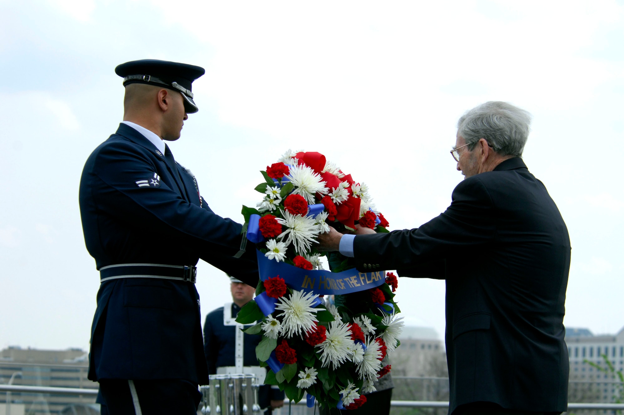 Airman 1st Class Kirk Campbell and former 1st Lt. Edward L. "Mac" McNally place a wreath at the Air Force Memorial April 24. The ceremony honored Lieutenant Mcnally and other crew members of the "Flak Man" B-24 Liberator from World War II. (U.S. Air Force photo/Tech. Sgt. Cohen A. Young)