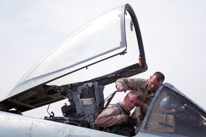 AL ASAD AIR BASE, Iraq — Phenix City, Ala. native crew chief Staff Sgt. Steve Young helps A-10 pilot 1st Lt. Chris "Harpoon" Laird strap in for a combat mission over Al Anbar Province in western Iraq. The lieutenant deployed here with the 74th Fighter Squadron, 438th Air Expeditionary Group, which is assigned to the 332nd Air Expeditionary Wing, the only Air Force wing in Iraq. The group activated Jan. 15, 2007, to provide close air support for Coalition Forces in the region. Within hours of standing up as a fully operational combat flying unit, the group was launching its fierce 'Warthogs' into battle. The A-10's distinctive nose art has been known to strike fear into enemy combatants unlucky enough to see its hungry, shark-toothed facade grinning at them. The Wichita, Kan. native lieutenant has flown about 30 combat missions in Iraq. (U.S. Air Force photo/Capt. Ken Hall)