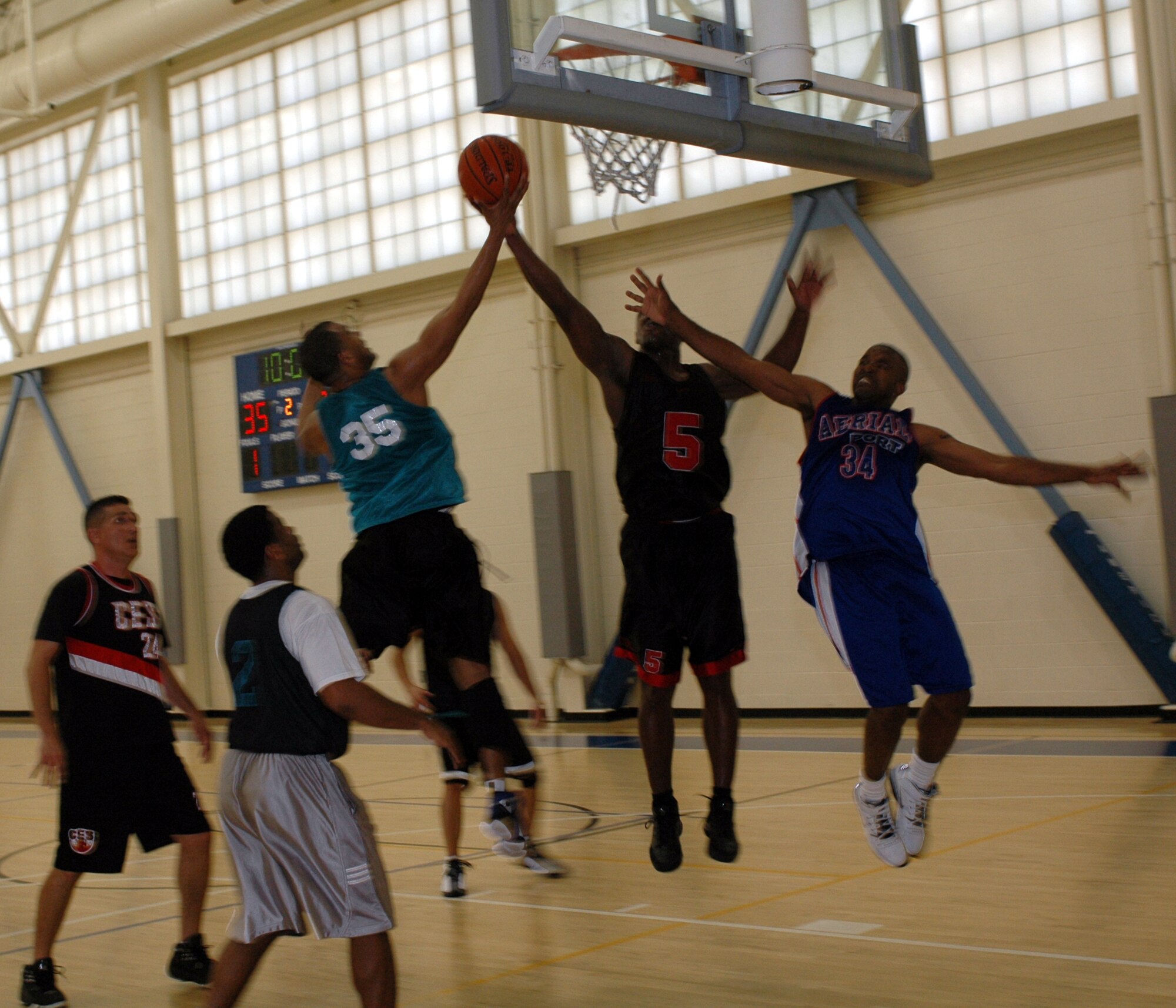 Rick Hunter, (#35), 60th Aerial Port Squadron shooting guard, Rob Hinderman, (#5) 60th Civil Engineer Squadron power forward, and Jeff Comer, (#34), 60th APS power forward, battle for the rebound during the Over 30 Basketball League championship April 25. The 60th CES won 55-41 to capture the season’s title. (U.S. Air Force photo by Staff Sgt. Candy Knight)