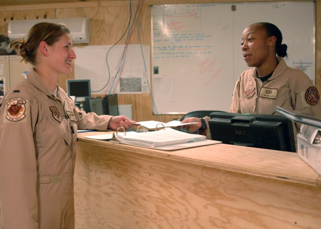 AL ASAD AIR BASE, Iraq — A-10 Thunderbolt II pilot 1st Lt. Kristin "Norris" Kleinhence discusses training requirements with Airman 1st Class Breyon Carter, one of the squadron's aviation resource managers. The lieutenant is the only female pilot deployed with the 74th Fighter Squadron, 438th Air Expeditionary Group, which is assigned to the 332nd Air Expeditionary Wing, the only Air Force wing in Iraq. The group activated Jan. 15, 2007, to provide close air support for Coalition Forces in the region. Within hours of standing up as a fully operational combat flying unit, the group was launching its fierce 'Warthogs' into battle. The A-10's distinctive nose art has been known to strike fear into enemy combatants unlucky enough to see its hungry, shark-toothed facade grinning at them. (U.S. Air Force photo/Capt. Ken Hall)