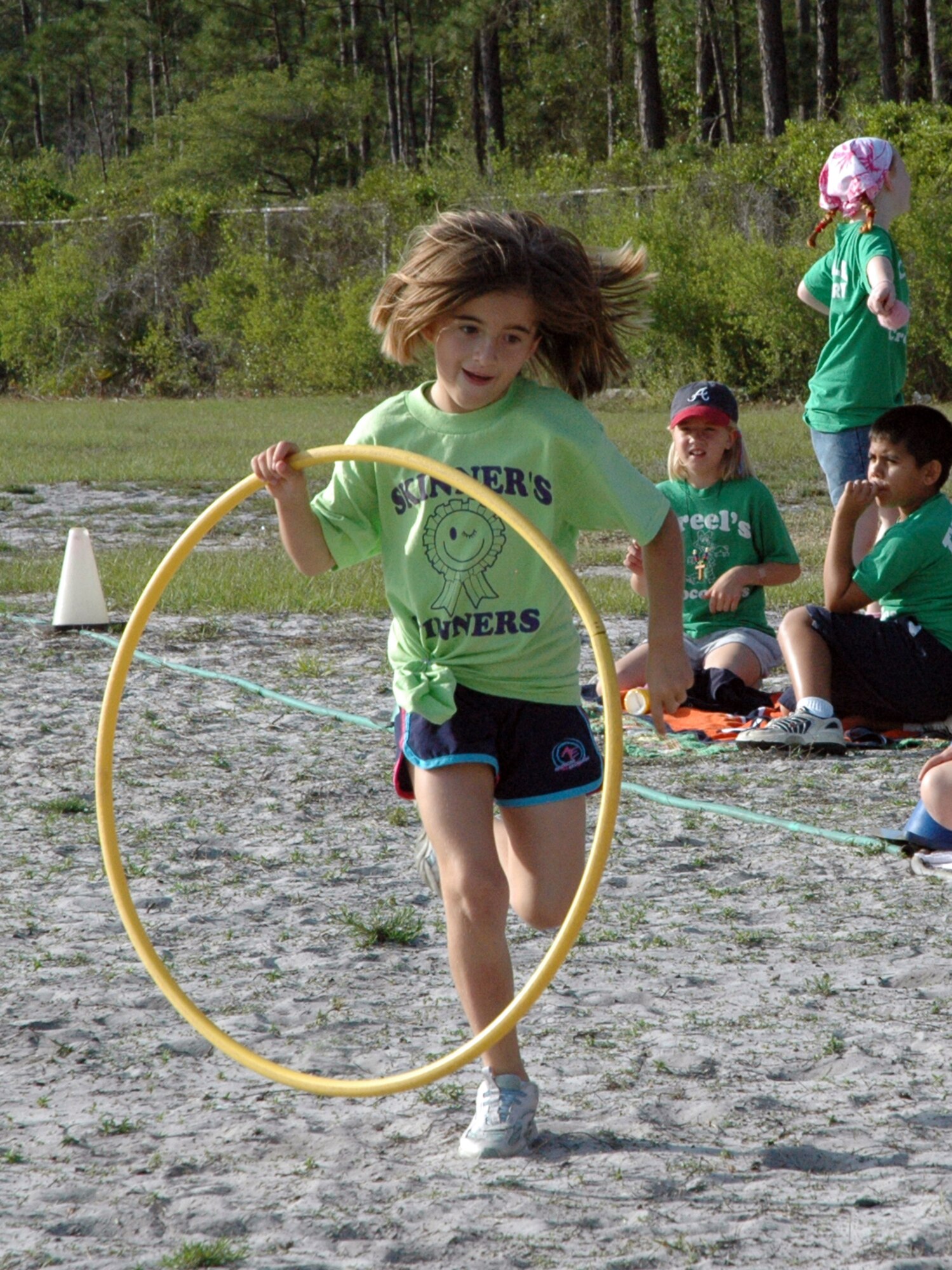 Eva McNally, 8, runs toward her Skinner’s Winners teammates in the hula hoop relay during Tyndall Elementary School’s annual Field Day Thursday. (U.S. Air Force photo by Chrissy Cuttita)