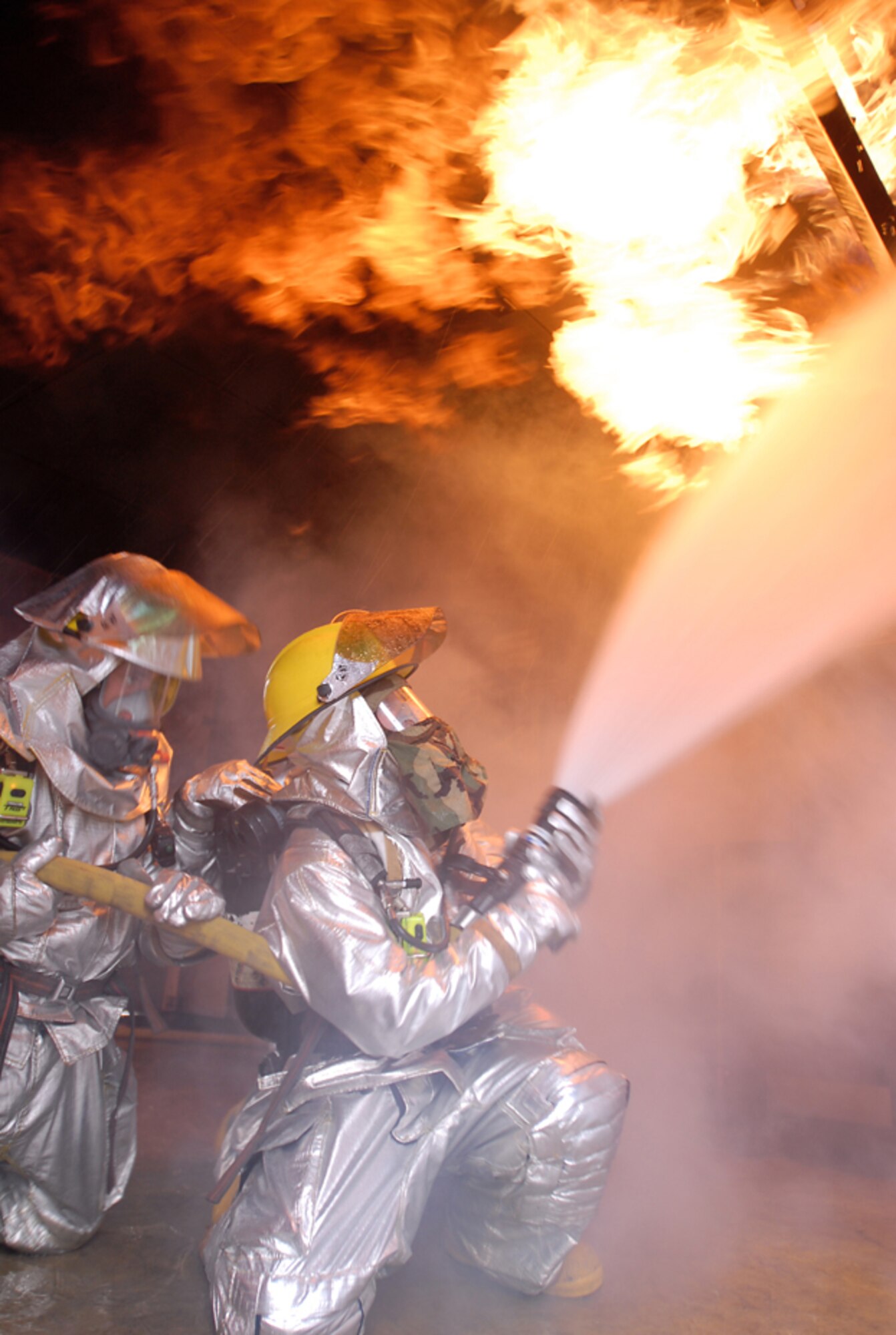 070425-F-4022T-089.jpg
KADENA AIR BASE, Japan -- Airman Lucas Simmons and Senior Airman Oscar Lopez douse flames in a simulated kitchen fire during Exercise Beverly High 07-02 activities. Airman Simmons is assigned to the 18th Civil Engineer Squadron, while Airman Lopez is assigned to the 482nd CES, a reserve unit from Homestead Air Reserve Base, Fla. The 482nd has been conducting joint training missions with their Kadena active-duty counterparts.  This was part of week-long exercise activities designed to test the wing's ability to mobilize personnel and cargo, respond to crises, and project combat airpower.  (U.S. Air Force photo by Airman 1st Class Kelly Timney)
