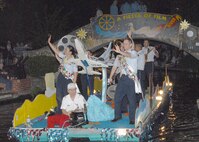 Lackland Ambassadors Tech. Sgt. Magadelena Cortez and Capt. C. Brent Dishman wave to spectators during the Texas Cavaliers River Parade April 23 at the San Antonio River Walk. Sergeant Cortez is assigned to the 737th Training Group. Captain Dishman is assigned to the 37th Training Wing. (USAF photo by Alan Boedeker) 