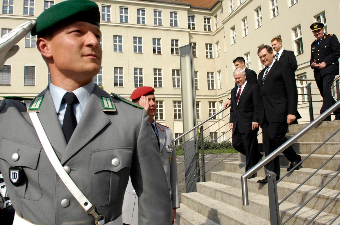 German military members salute as U.S. Defense Secretary Robert M. Gates and German Minister of Defense Franz Josef Jung exit the Ministry of Defense in Berlin, April 25, 2007.