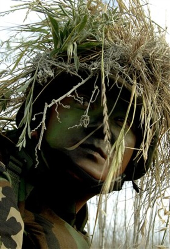 U.S. Air Force Airman 1st Class Johnathan Foster looks back at his squad-mates during the survival and evasion portion of exercise Quick Shot at Camp Pendleton, Calif., on April 22, 2007.  Quick Shot is a semi-annual field exercise designed to integrate and enhance the war-fighting capabilities of joint and combined combat photographers with their foreign counterparts.  Foster is assigned to the 30th Space Communications Squadron.  