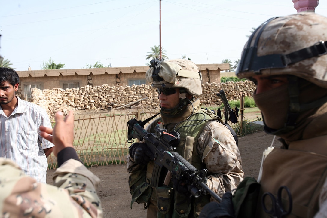 Gunnery Sgt. Fernando L. Llanos, 33, from Queens, N.Y., speaks to his interpreter while on patrol with soldiers from 1st Brigade, 3rd Battalion, 1st Iraqi Army Division. Llanos is the senior advisor for Company 2 and he embeds with the Iraqi Army to help make the unit self-sustainable and capable of independent combat operations. He is with the Military Transition Team, which originated from 3rd Battalion, 6th Marine Regiment.