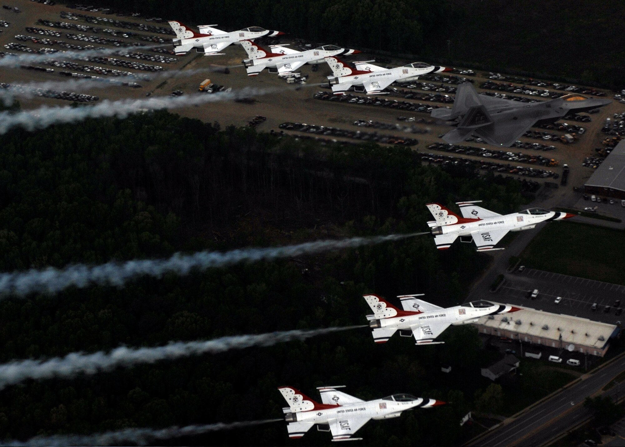 Maj. Max Moga, F-22A Raptor demonstration pilot, leads six Thunderbird F-16s in formation over Langley Air Force Base, Va., during their practice day April 27 for the Airpower Over Hampton Roads air show scheduled April 28-29. This year the Thunderbirds and the F-22 demonstrations commemorate the 60th Anniversary of the United States Air Force. (U.S. Air Force photograph/Tech. Sgt. Justin D. Pyle)
