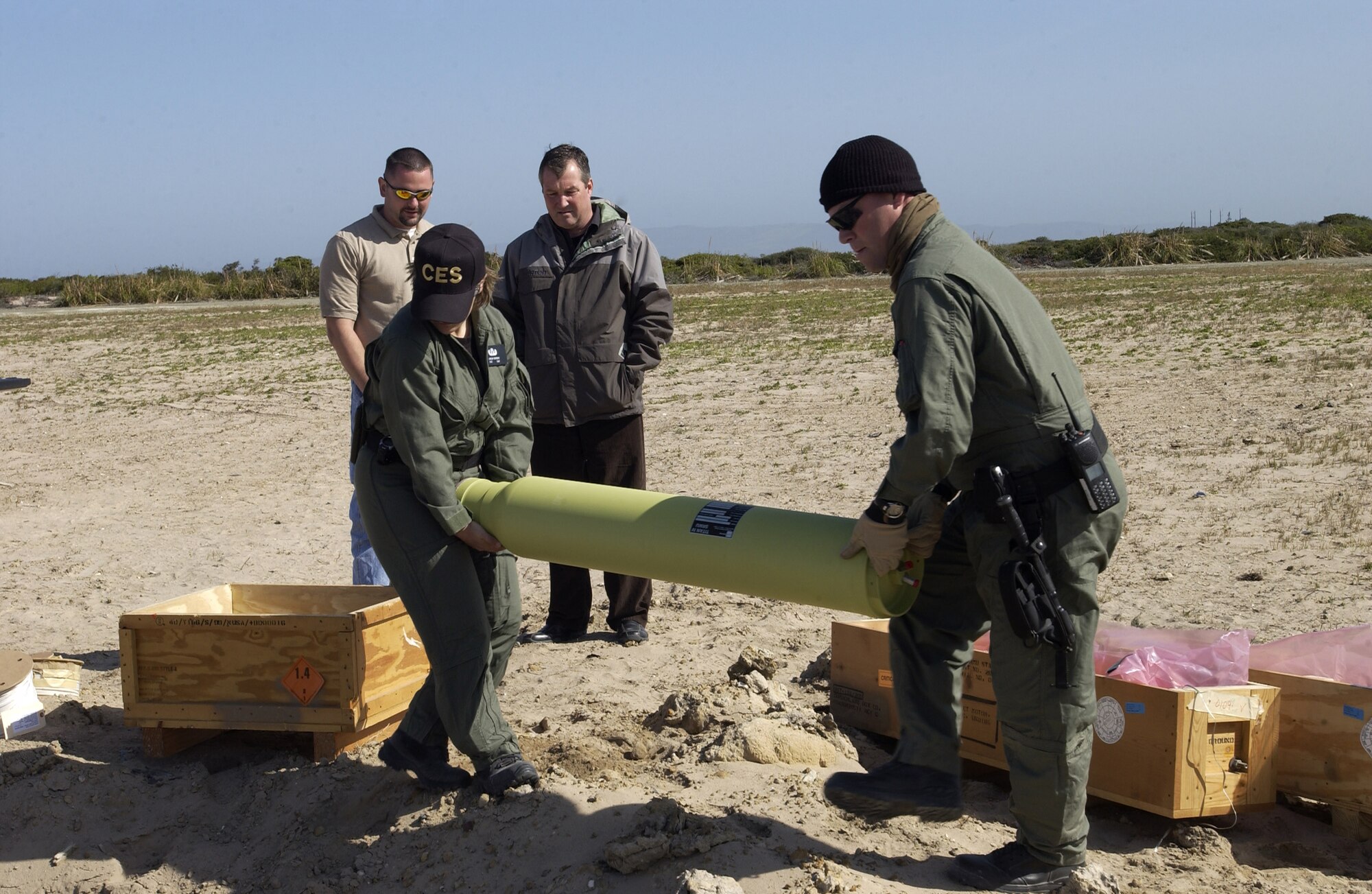 Packing a detonation pit with ordnance for disposal, Staff Sgt. Lindsay Brendan and Staff Sgt. Robert Brown move a Titan IV staging motor at Vandenberg April 25.  30th Civil Engineer Squadron Explosive Ordnance Disposal technicians used 500 pounds of C-4 to destroy two caches of various rocket material including Titan II pressure cartridges, linear explosive assemblies and detonators. (Photo by Airman 1st Class Ashley Tyler)