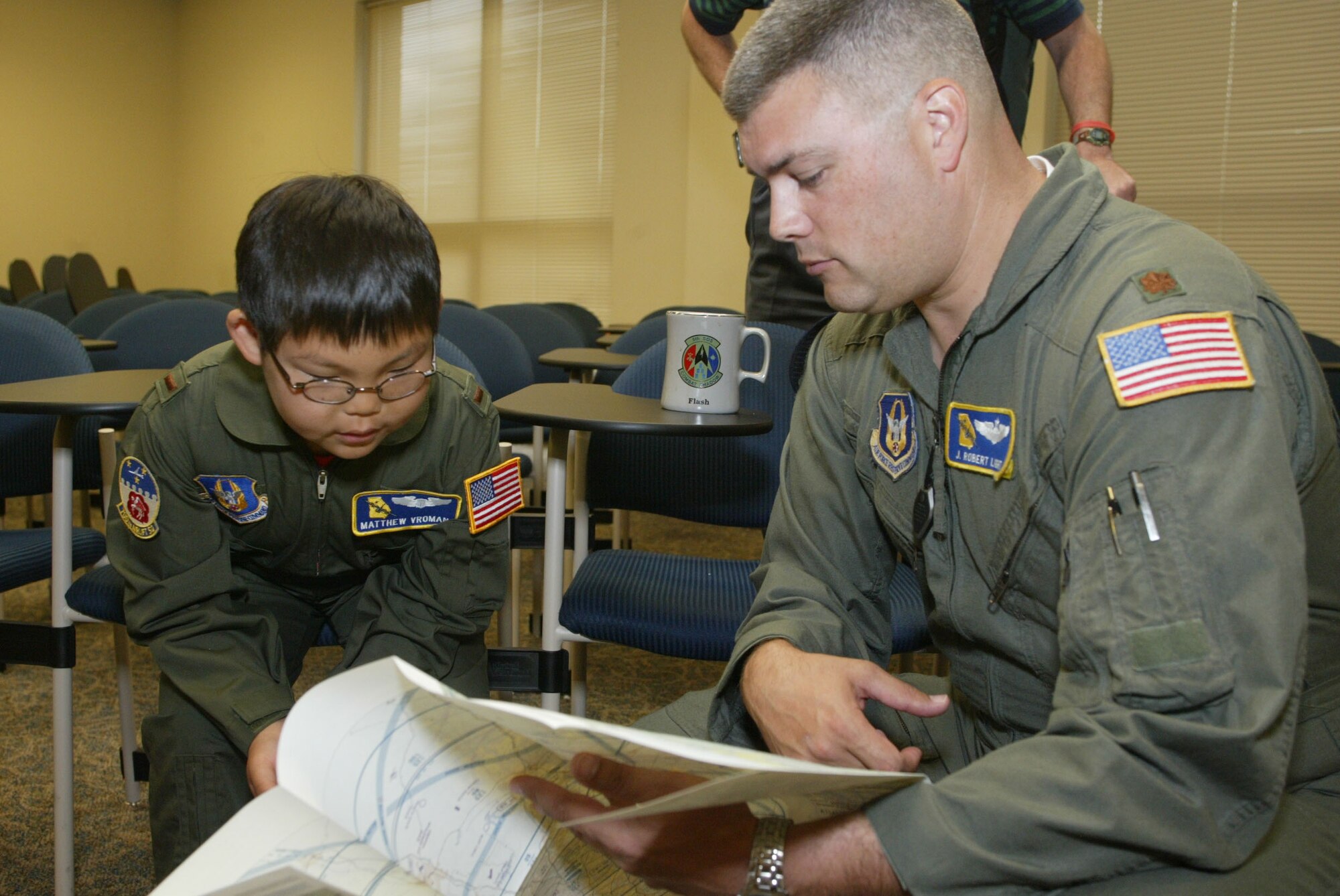 Honorary 2nd Lt. Matthew Vroman reviews a map with Maj. Robert Light as a part of his preflight briefing during a Make-A-Wish event at Dobbins Air Reserve Base, Ga.