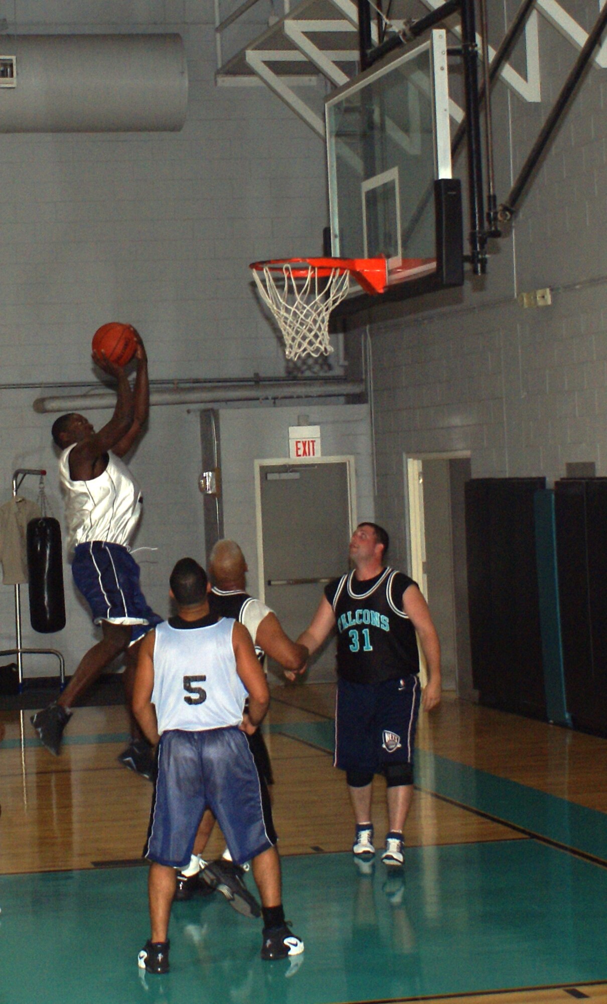 Arjewus Willis, a center for the Southern Command B team attempts a jump shot over two defenders from the Homestead Air Reserve Base Security Forces team during a recent basketball game at Homestead ARB.  Southern Command is represented by two teams in the Homestead’s intramural basketball league, and both teams finished the regular season with a record of five wins and one loss.  The playoffs begin the week of April 30 with the teams from Southern Command ranked as the top two seeds out of seven teams. (U.S. Air Force photo/Jake Shaw)