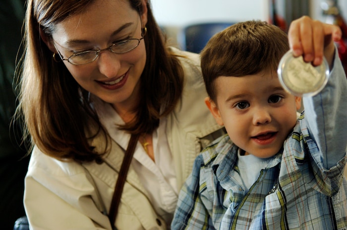Zachary Moore shows off his new 17th Airlift Squadron coin with his mother, Kimberly Moore. He received the coin from Maj. Brett King, assistant director of operations, when Zachary was the Pilot for a Day April 20. (U. S. Air Force photo/Airman 1st Class Nicholas Pilch)