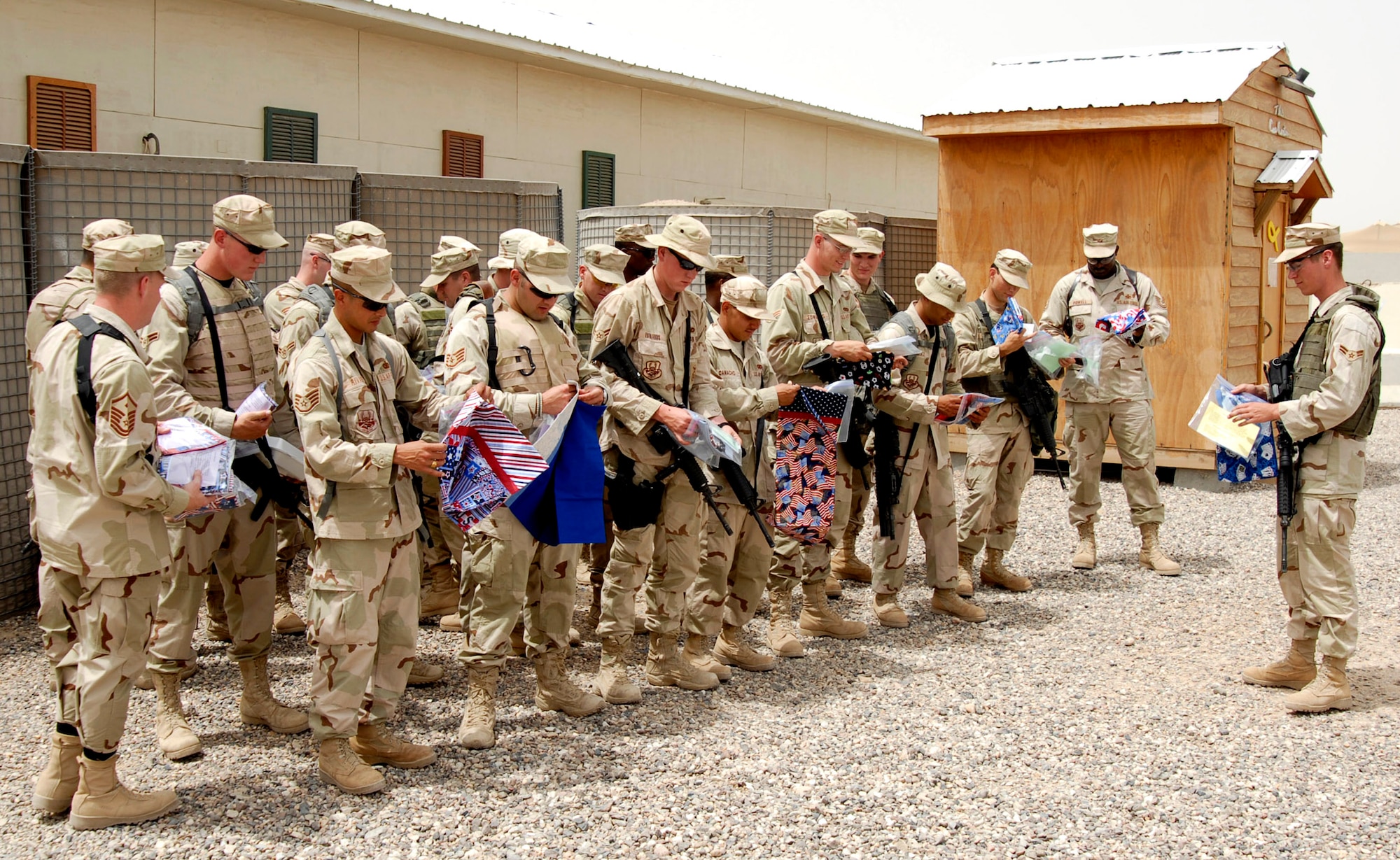 Members of the 886th Expeditionary Security Forces Squadron receive pillowcases made and donated by the community of Concord, Calif., April 24 at Camp Bucca, Iraq. Operation Pillowcase gave members of the 886th ESFS a reminder of home. The project was spearheaded by Deborah Burrow, mother of Airman 1st Class Paul Beasley (far right) who is an 886th ESFS member. (U.S. Air Force photo/Elias Ibay)