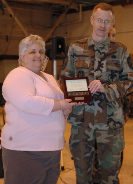 YOUNGSTOWN AIR RESERVE STATION,Ohio—Air Force Reserve Senior Master Sgt. Steven G. Bennett, an air transportation manager with the 76th Aerial Port Squadron here, accepts the 910th?s 2007 Volunteer Excellence Award from Janice Barnes, 910th Family Support Director, at an Aerial Port group formation here during the April UTA. Bennett was recognized for his outstanding service to his hometown of Hudson, Ohio. U.S. Air Force photo/Senior Airman Ann W. Jefferson 