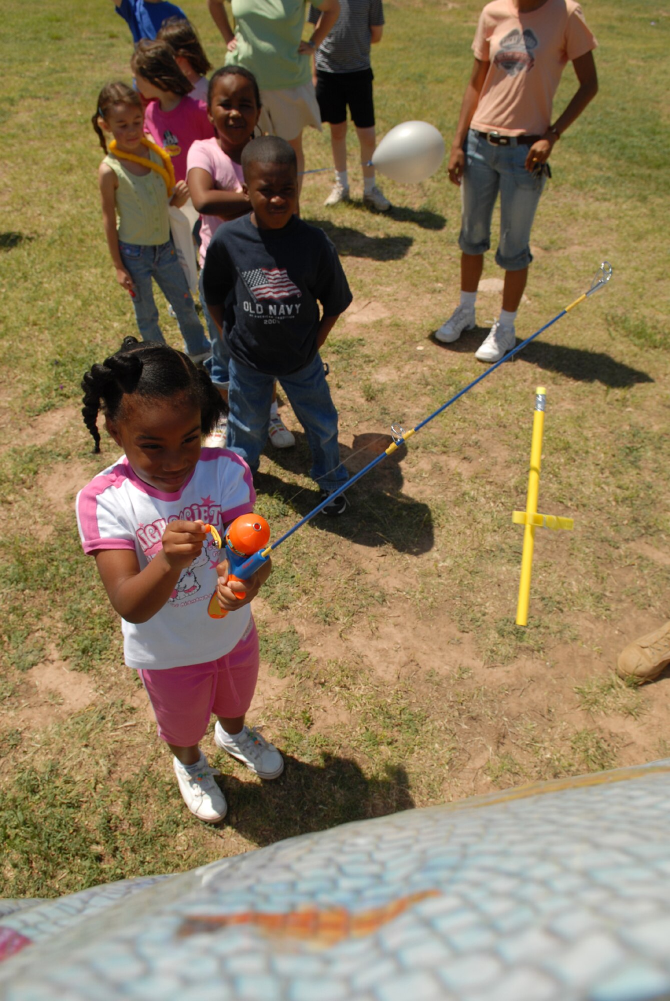 Kameryn Daniels, daughter of Sgt. First Class  Robert Daniel of the 344th Military Intelligence Battalion, reels in a big catch at the fishing booth during the Childrens Fest April 21. (U.S. Air Force photo by Tech. Sgt. Randy Mallard)