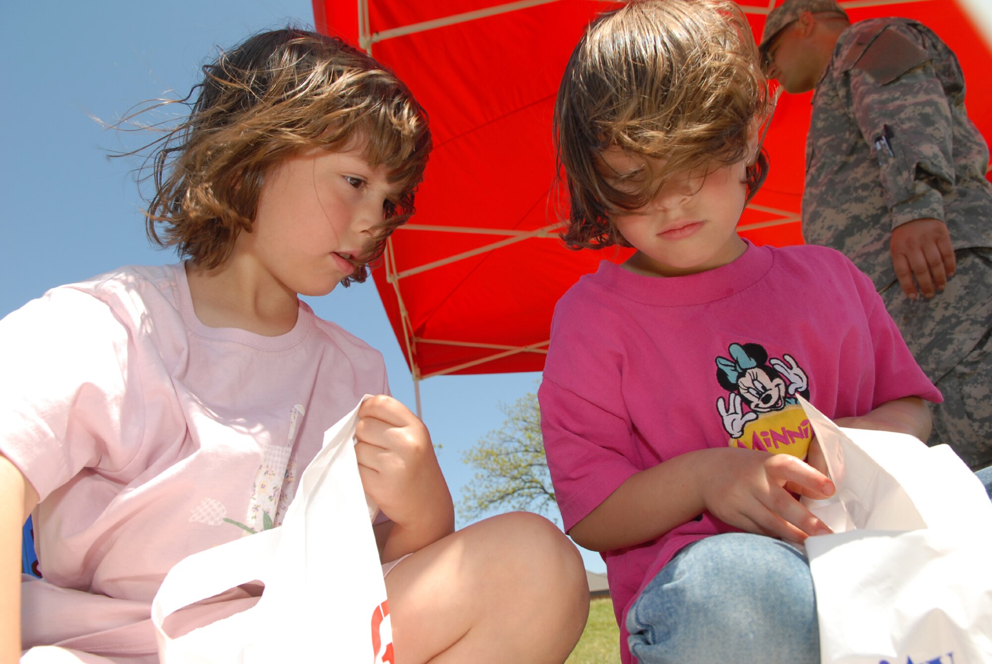 Rebekah and Sarah Mallard, daughters of Tech. Sgt. Randy Mallard of the 17th Communication Squadron, look at the available prizes after shooting hoops with an oversized basketball during the Childrens Fest April 21. (U.S. Air Force photo by Tech. Sgt. Randy Mallard)
