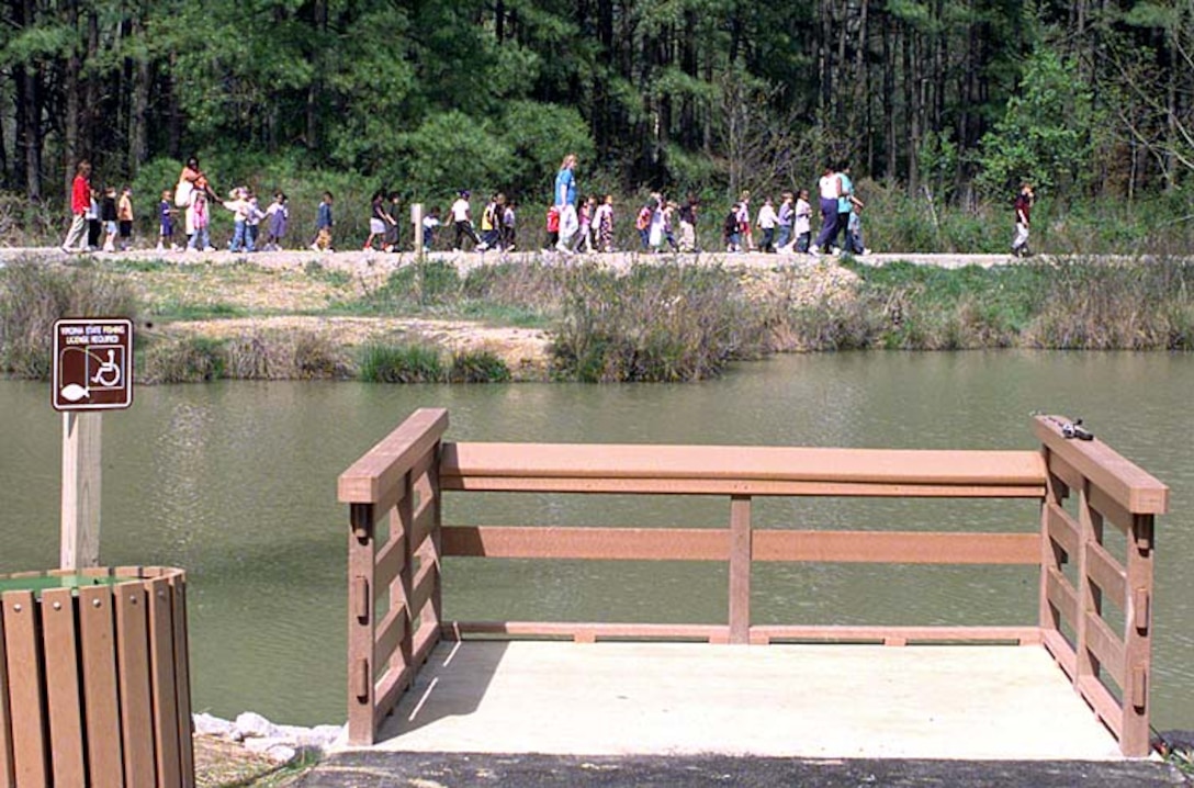 The renovated pond at the Fort Belvoir, Va., Jackson Miles Abbott Wetlands Refuge includes three plastic fishing piers for anglers. Children from Belvoir's North Post day care center tour the new 146-acre refuge during Earth Day ceremonies. Rudi Williams 