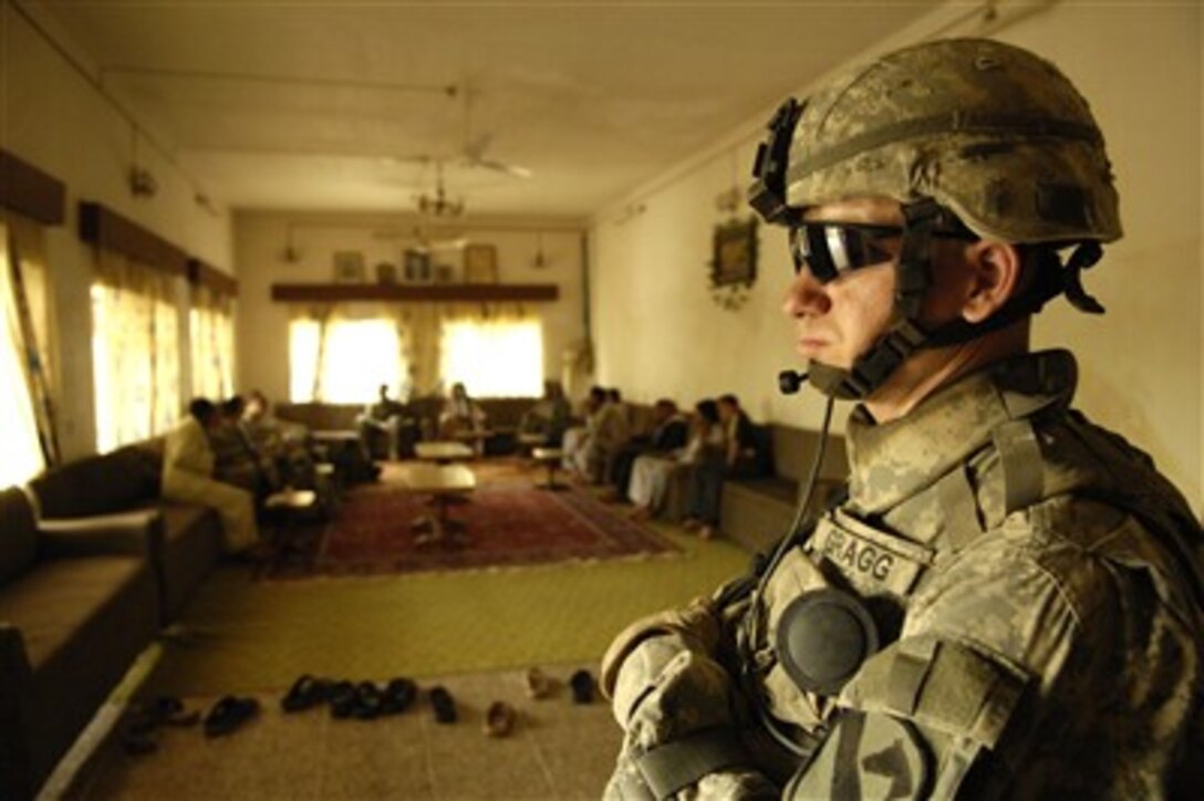 A U.S. Army soldier from the 6th Battalion, 9th Armored Reconnaissance Squadron, 3rd Brigade Combat Team, 1st Cavalry Division, provides door security during a meeting with local citizens about water canal cleanup in the Northern Diyala province region of Iraq, on April 24, 2007.  