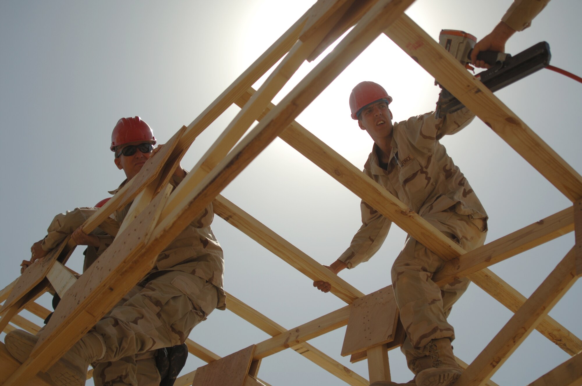 AL ASAD AIR BASE, Iraq -- Master Sgt. Mike Judd (left) and Airman 1st Class Justin Hamilton, 557th RED HORSE Squadron, install roof trusses over the new weapons armory for use by Marines at Al Asad.  Sergeant Judd deployed from the 202nd RED HORSE Squadron at Camp Blanding, Fla., and Airman Hamilton from the 366th Civil Engineer Squadron at Mountain Home AFB, Idaho. The RED HORSE's main mission at Al Asad was to ready facilities there to 'bed down' a squadron of A-10 Thunderbolt IIs and its Air Expeditionary Group to provide close air support to Coalition Forces in the region. (U.S. Air Force Photo/Capt. Ken Hall)