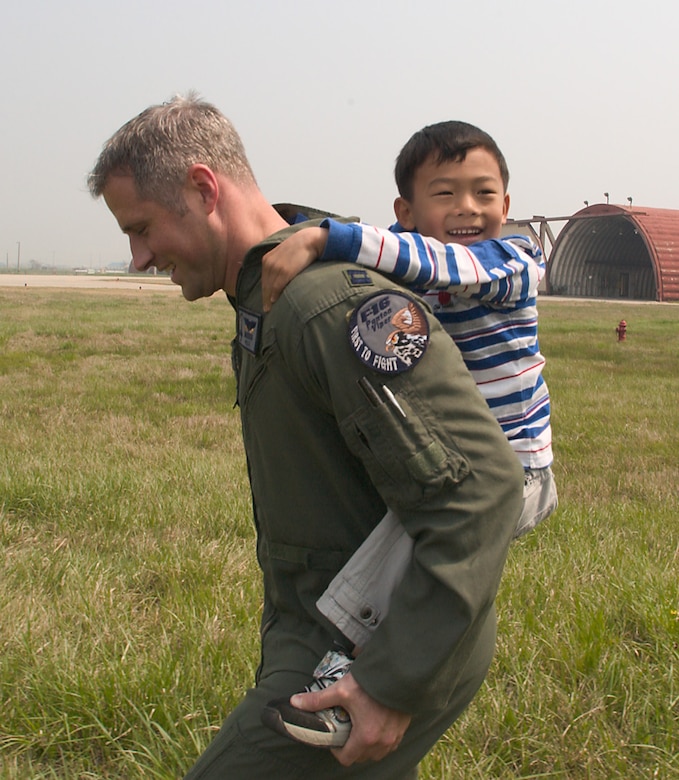 KUNSAN AIR BASE, Republic of Korea  April 27, 2007 -- Capt. Tom Still, 35th Fighter Squadron fighter pilot, gives a piggy back ride to a Gunsan City orphanage child during his visit here April 27. The 35th FS hosted the orphanage as part of the 8th Fighter Wing's Good Neighbor Program commitment to supporting the community. The 35th, known as the "Pantons," is one of two F-16 Fighting Falcon squadrons assigned to the 8th Fighter Wing here. (U.S. Air Force photo/Senior Airman Barry Loo.)
