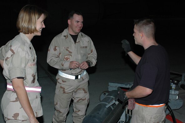 Senior Airman David Beatty, 379th ELRS Fuels Management Flight, chats with Lt. Col. Kristina O’Brien, 379th ELRS commander, and Capt. John Klohr, 379th Fuels Management Flight commander, after pumping the billionth gallon of fuel. (U.S. Air Force photo/Senior Airman Erik Hofmeyer)