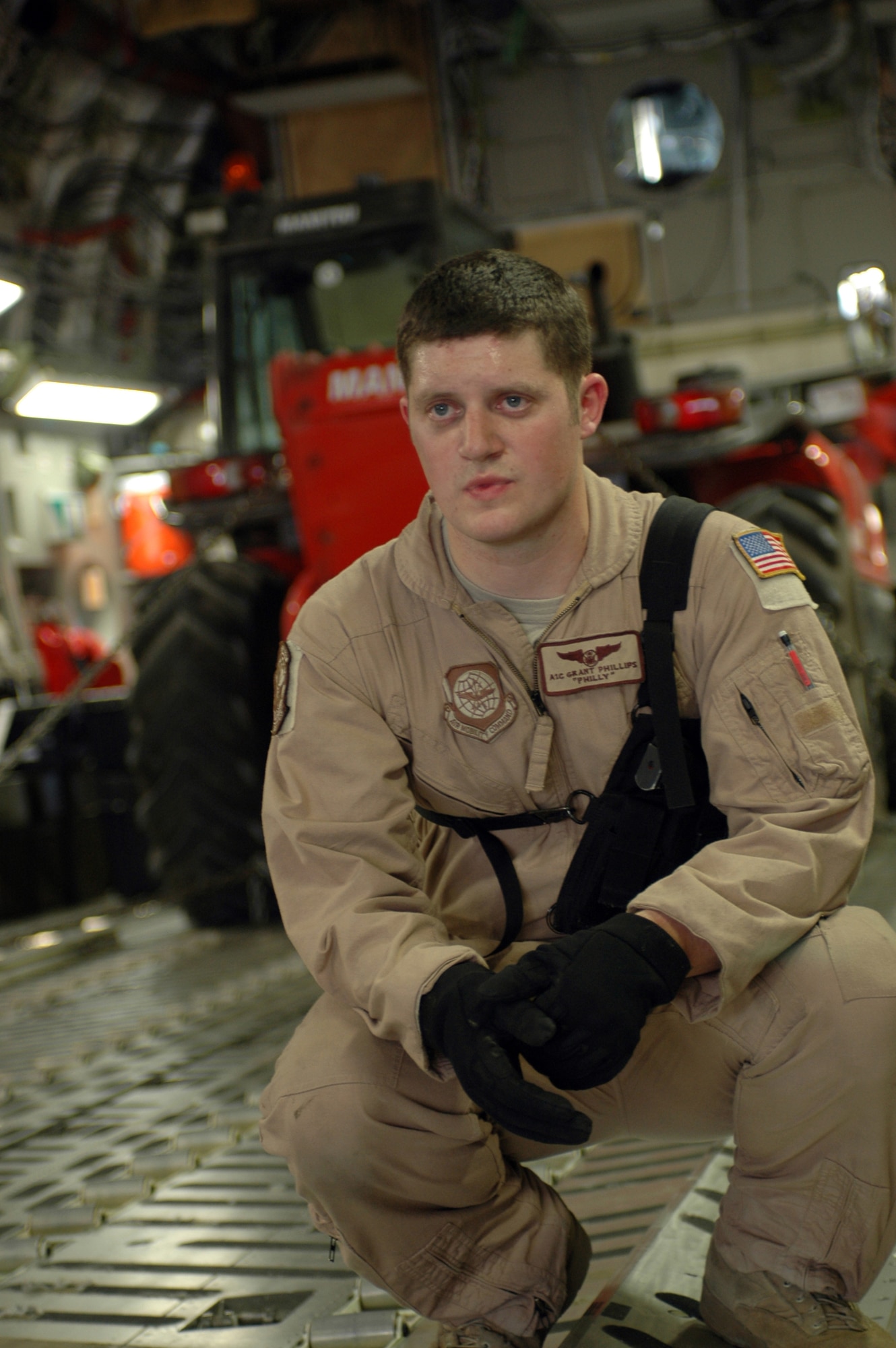 Airman 1st Class Grant Phillips, 816th Expeditionary Airlift Squadron loadmaster, watches as aerial porters prepare palletized cargo for loading onto a C-17 Globemaster Tuesday. The 816th EAS is approaching the end of it’s rotation after airlifting over 120 million pounds of cargo since Dec. 31.  (U.S. Air Force photo/Senior Airman Erik Hofmeyer)