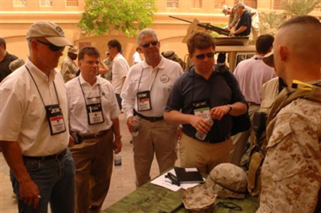 Members of the Joint Civilian Orientation Conference 73 talk with a member of the Marine security team assigned to protect the assets and personnel assigned to U.S. Naval Central Command Headquarters in Bahrain, April 26, 2007.