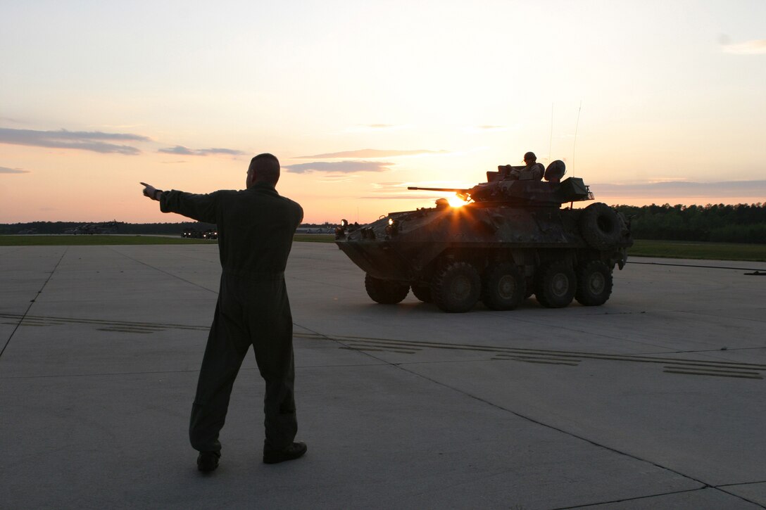 Sgt. Mark Chapman, a loadmaster with Marine Aerial Refueling Transport Squadron 252, directs a Light Armored Vehicle (LAV) away from a Rapid Ground Refueling point at Blackstone Army Air Field, near Fort Pickett, Va., April 28, 2007. The LAV is with Light Armored Reconnaissance Platoon, Weapons Company, Battalion Landing Team, 3rd Battalion, 8th Marine Regiment, 22nd Marine Expeditionary Unit. The Marines and Sailors of BLT 3/8 are scheduled to deploy as the Ground Combat Element of the 22nd Marine Expeditionary Unit later this year. (Official Marine Corps photo by Sgt. Matt Epright)