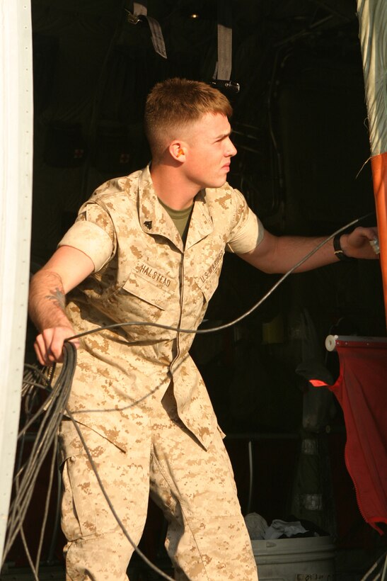 Cpl. Johnathon Halstead, a satellite communications operator with the 22nd Marine Expeditionary Unit Command Element, untangles cables to headphone microphones for C-130 pilots at a Rapid Ground Refueling point established by Marine Aerial Refueling Transport Squadron 252 at Blackstone Army Air Field, near Fort Pickett, Va., April 28, 2007. Halstead was attached to the aircraft crew for the duration of the 22nd MEU’s Realistic Urban Terrain training exercise. The aircraft crew came to refuel humvees and Light Armored Vehicles from Light Armored Reconnaissance Platoon, Weapons Company, Battalion Landing Team, 3rd Battalion, 8th Marine Regiment, 22nd Marine Expeditionary Unit. The Marines and Sailors of BLT 3/8 are scheduled to deploy as the Ground Combat Element of the 22nd Marine Expeditionary Unit later this year. (Official Marine Corps photo by Sgt. Matt Epright)