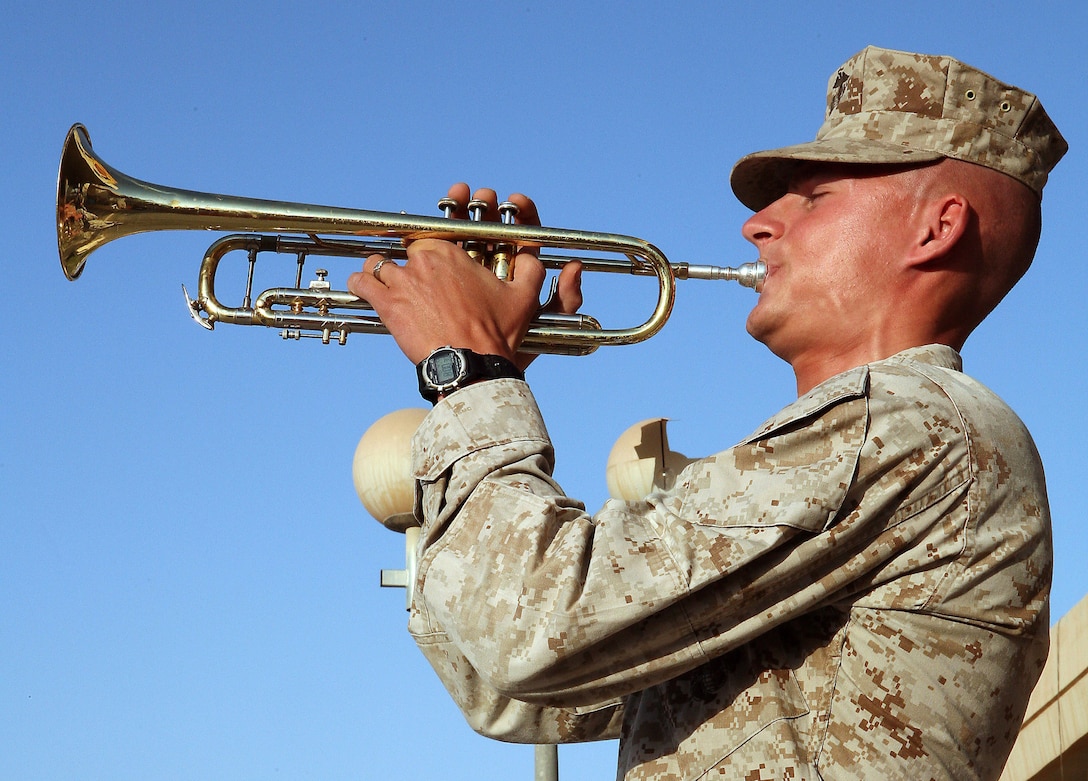 Marine Sgt Austin Hunt, a trumpet player with the 2nd Marine Aircraft Wing Band and a member of the Tactical Air Control Center security force in Al Asad, Iraq, plays morning colors outside the center, April 10, 2007. U.S. Marine Corps photo by Cpl. Zachary Dyer
