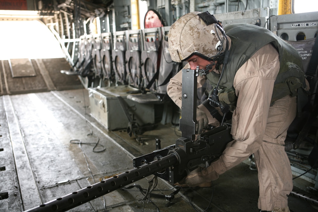 Sgt. Joshua Groh, a crew chief and mechanic for Marine Heavy Helicopter Squadron 362, tries to repair a M2 .50 Caliber Heavy Machine Gun during a flight, May 30. The Marines were testing the weapons systems at a local range.