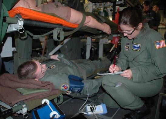 WRIGHT-PATTERSON AFB -- Aeromedical technician Staff Sgt. Rachel Reed checks on a simulated patient, Tech. Sgt. Joseph Drake, in flight on a C-17 Globemaster III while the medical crew is put to the test with a variety of scenarios by medical flight instructors. Five squadrons and about 80 medical personnel from California, Florida, Maryland and Georgia participated in the Air Force Reserve Aeromedical Evacuation Jamboree held April 28 and 29 at Wright-Patterson Air Force Base, Ohio. Both sergeants are from the 445th Aeromedical Evacuation Squadron. (U.S. Air Force photo/Tech. Sgt. Charlie Miller)