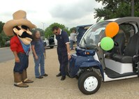 Hazardous Material Program Manager Monico Luna, 37th Civil Engineer Squadron, explains the environmental benefits of an electric car to an Earth Day attendee and Sheriff R.E. Cycle from the 37th CES Recycling Center April 23 at the base exchange parking lot on Lackland Air Force Base, Texas. The car is used for transportation around the base by the 37th Mission Support Group commander and staff. (USAF photo by Alan Boedeker)                               