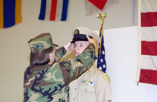 Seventeen-year-old Cody Blackshear receives his cover from Chief Petty Officer Gayle Marino as a symbol of progression from junior to senior enlisted. Cody was being promoted to chief petty officer within the U.S. Naval Sea Cadet Corps, located at March Air Reserve Base. (U.S. Air Force photo by SSgt Amy Abbott, 452 AMW/PA)