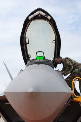 Major Karl D. Lewis, Air Force Reserve's 301st Fighter Wing chief of Public Affairs, takes a rare opportunity to inspect the F-22 Raptor, parked on the wing's ramp alongside the F-16 Falcon, as it makes a brief stopover at NAS JRB Fort Worth, Texas, while flying cross country. (U.S. Air Force Photo/Laura Dermarderosian-Smith)